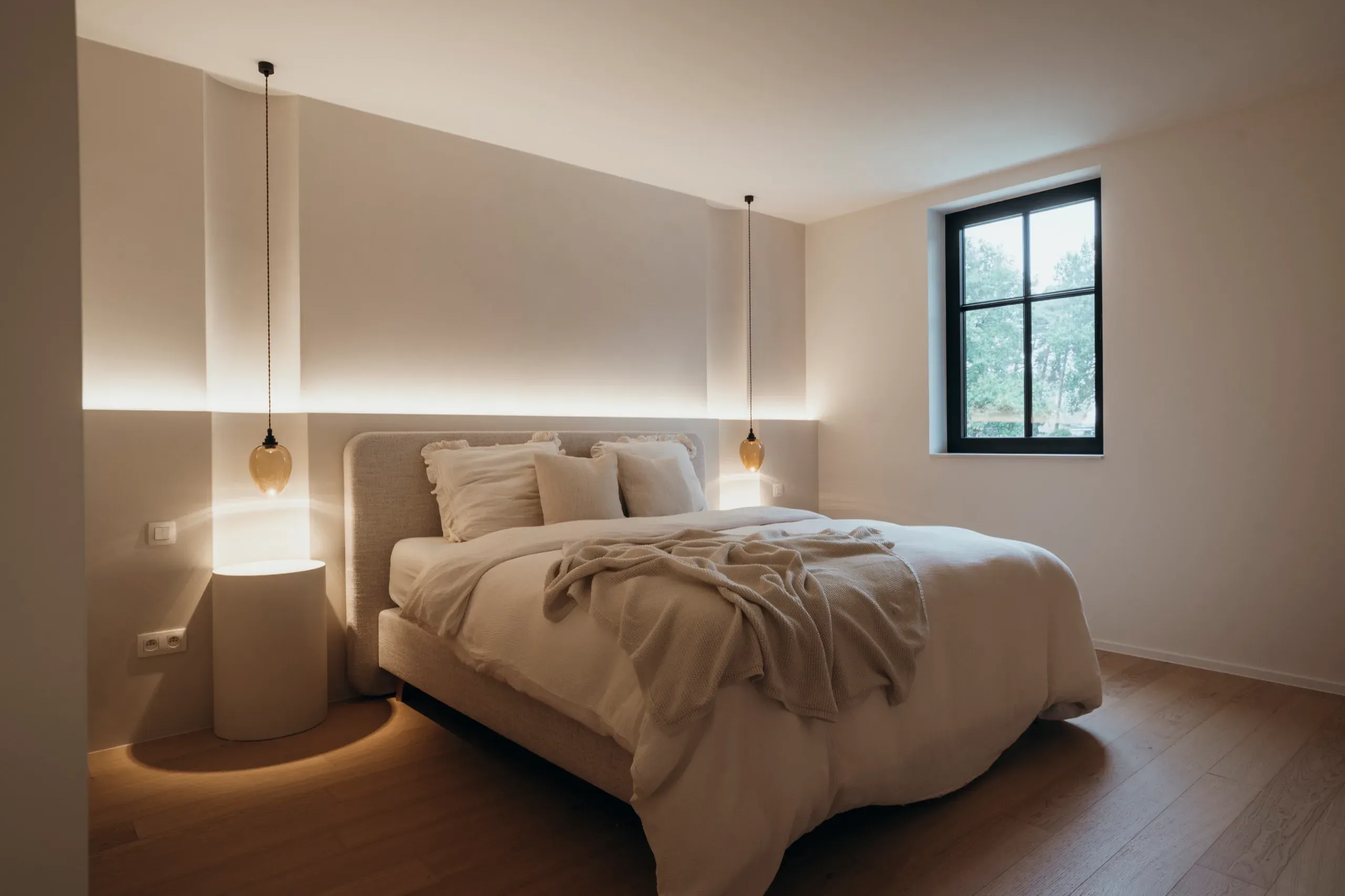 Slaapkamer met maatwerk hoofdbordwand en indirecte verlichting